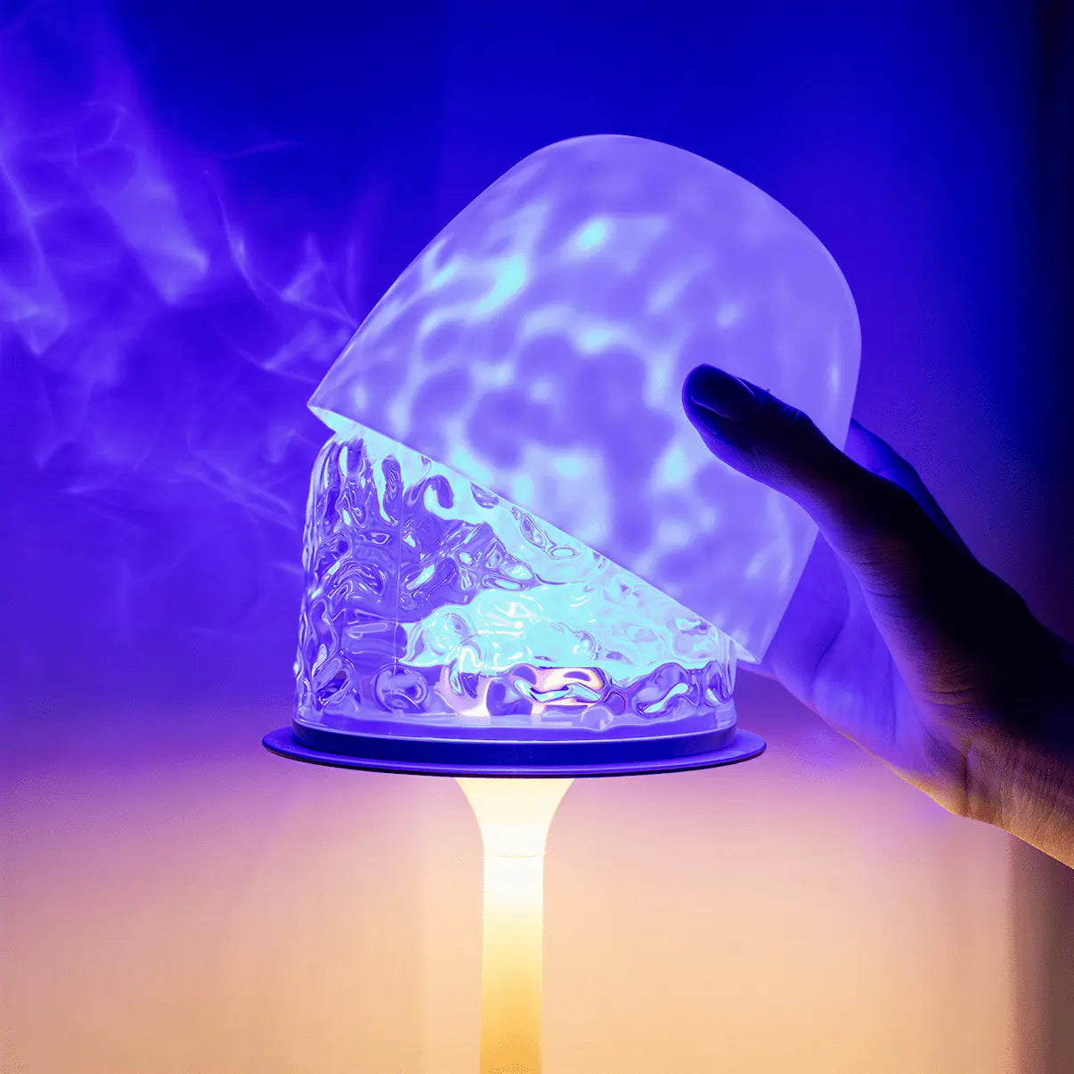 This close-up shot shows a hand lifting the semi-transparent frosted lampshade, revealing witlity skywave lamp rippled ice-crack glass inside, which casts dreamy flowing blue-purple light against the lamp stem's warm yellow glow, showcasing its detachable design, unique dual-light ambiance and decorative charm.