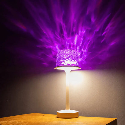 Matte milky white streamlined witlity skywave table lamp with a rippled ice-crack glass shade, emitting dreamy purple light that casts flame-like flowing radial patterns on the dark background. Soft warm white light glows below, placed on a light wooden table to create stunning artistic ambiance and offer practical lighting function.